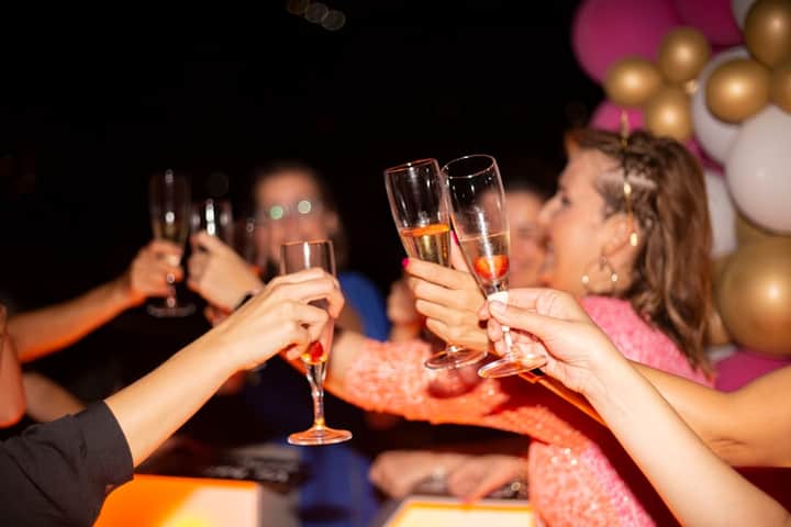 Friends raising glasses during a bride quiz